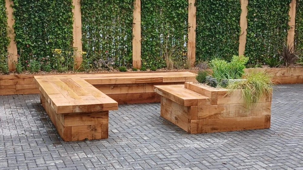 Finished outdoor space with plant walls and seating area between green plants