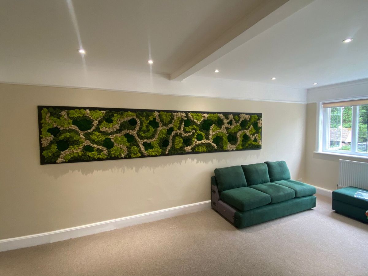 Moss art on a wall next to a couch