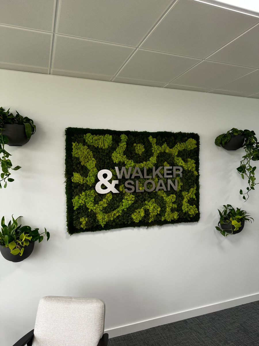 Moss art with company name and planters next to it