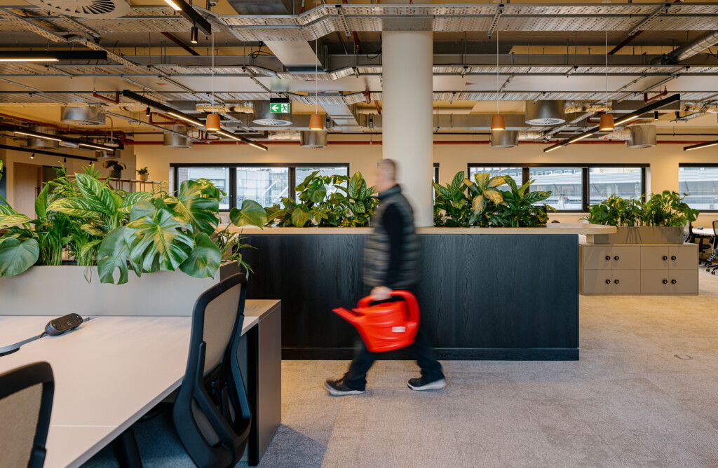 man walking past plants in the office