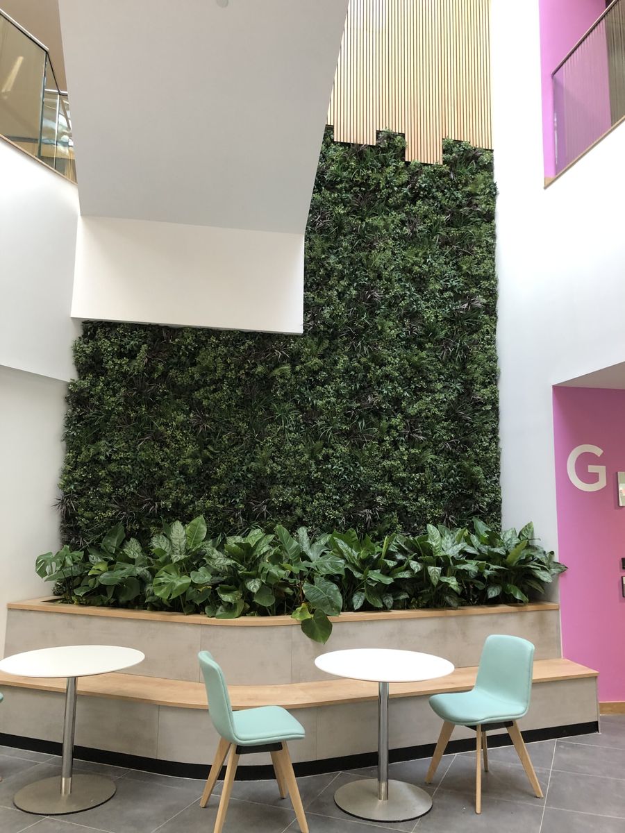 Green wall and plant bedding next to a seating area
