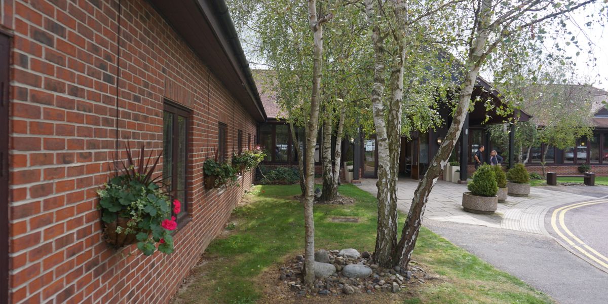 maintained lawn behind a brick building