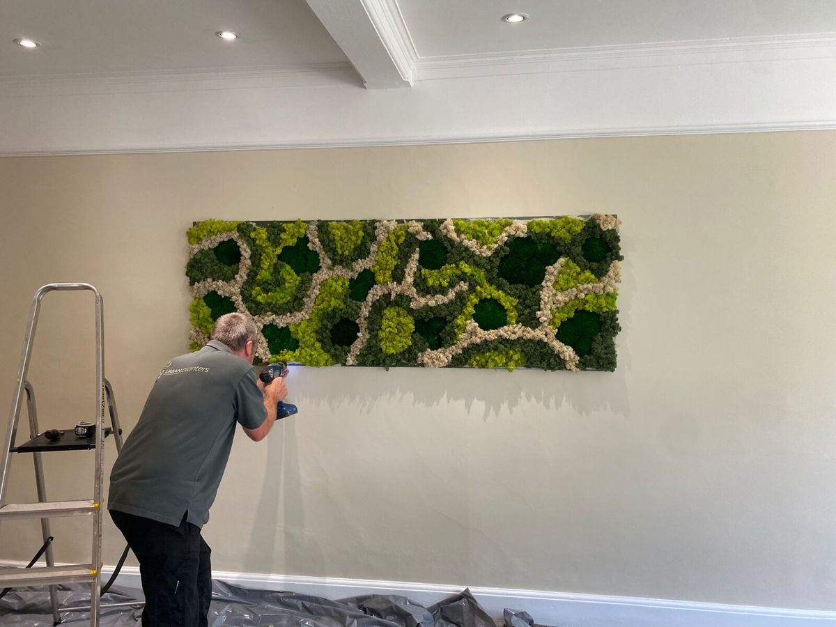 Urban Planters technician working on a moss wall art