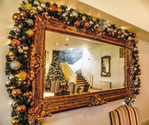 mirror reflecting a christmas tree by the stairs