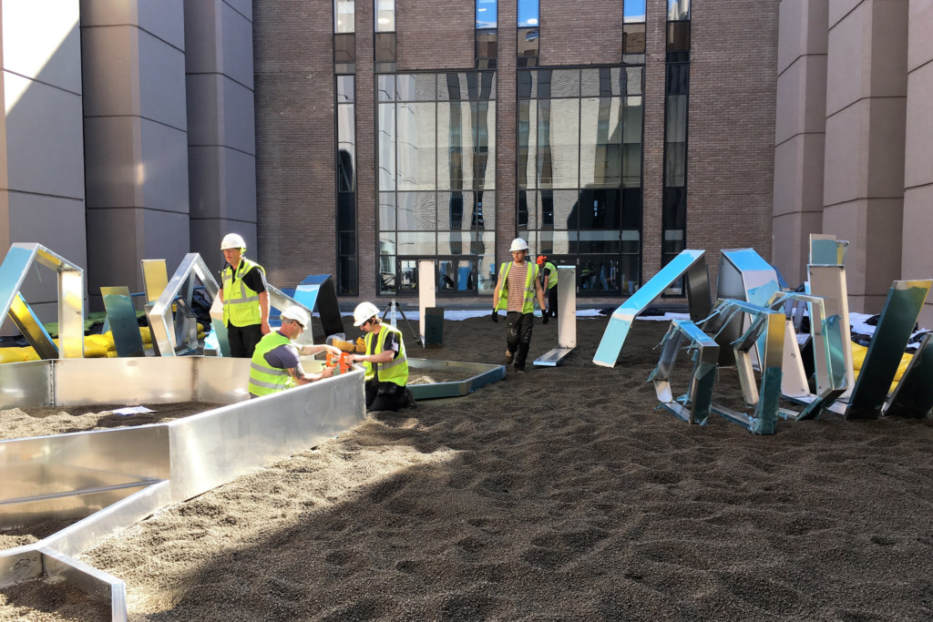 gardeners designing a plant structure outside university