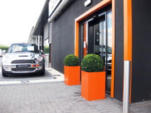 outdoor plants in bright orange pots outside a building