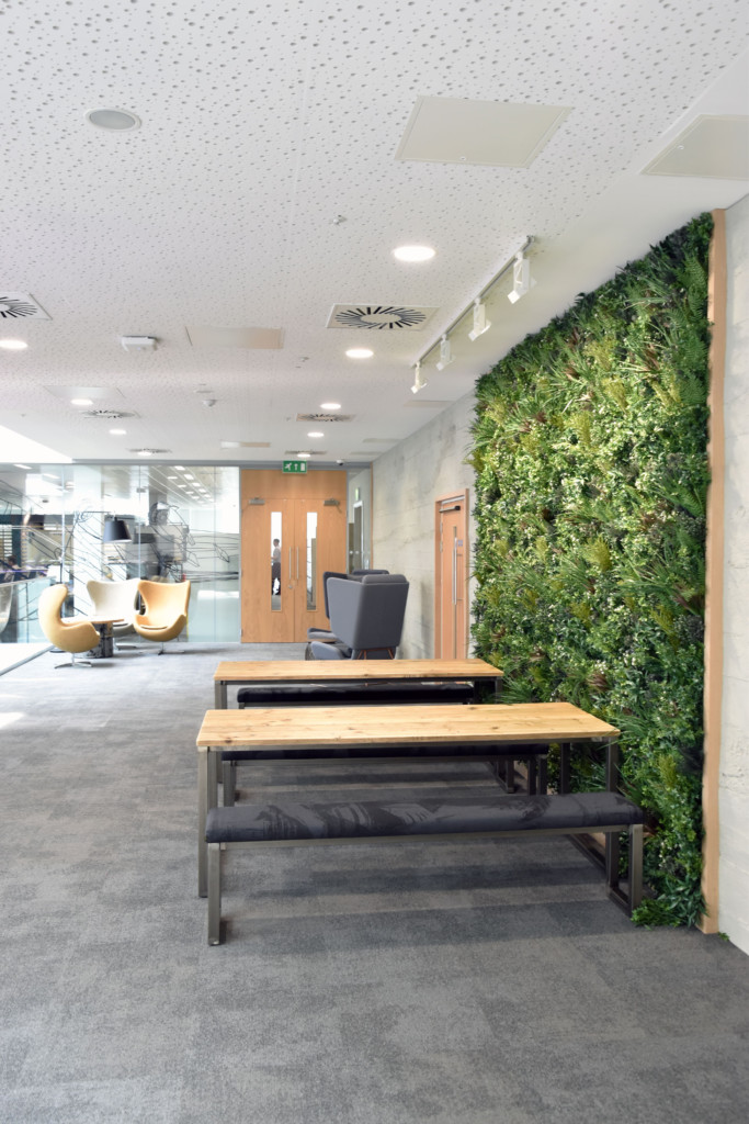 plant wall and wooden tables in a formal area