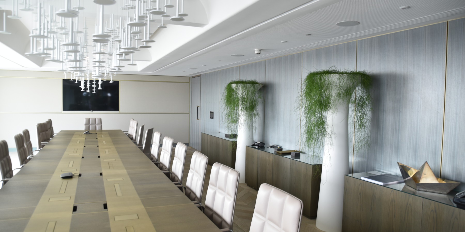 room with long table and plants displayed