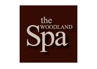 the woodland spa text with brown background