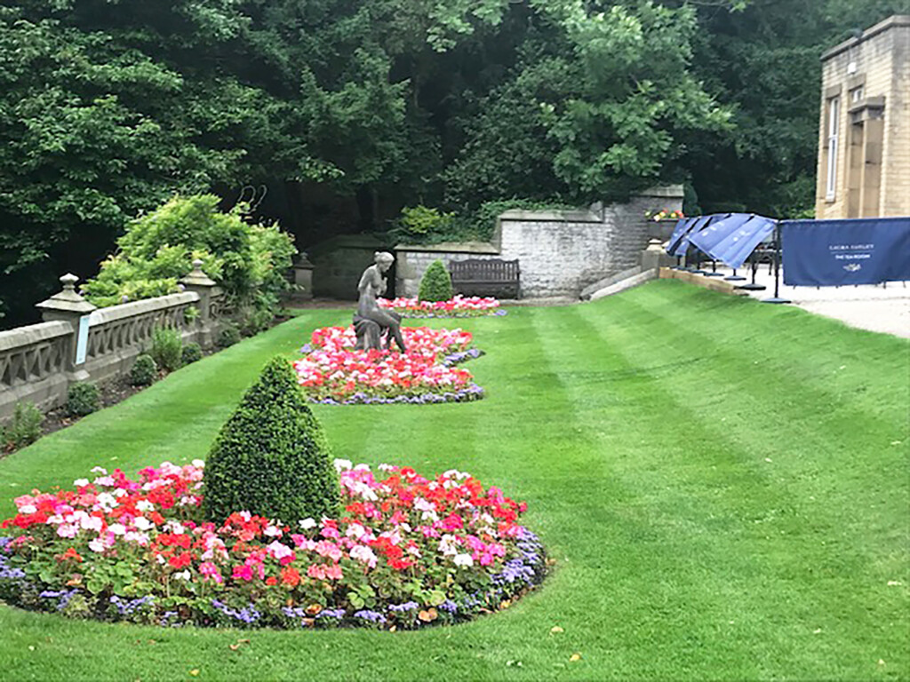 beautiful garden with flowers and a statue