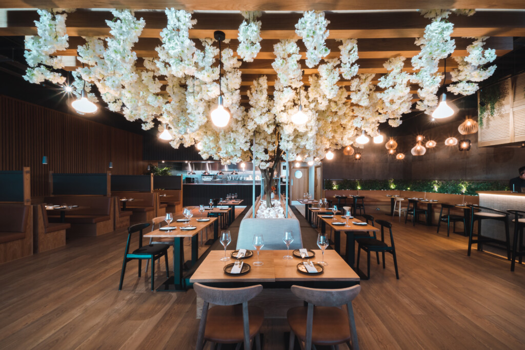 eatery with white tree growing all around the roof with hanging lights