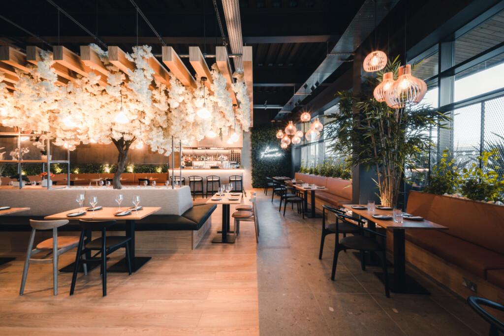 eatery with white tree growing all around the roof with hanging lights