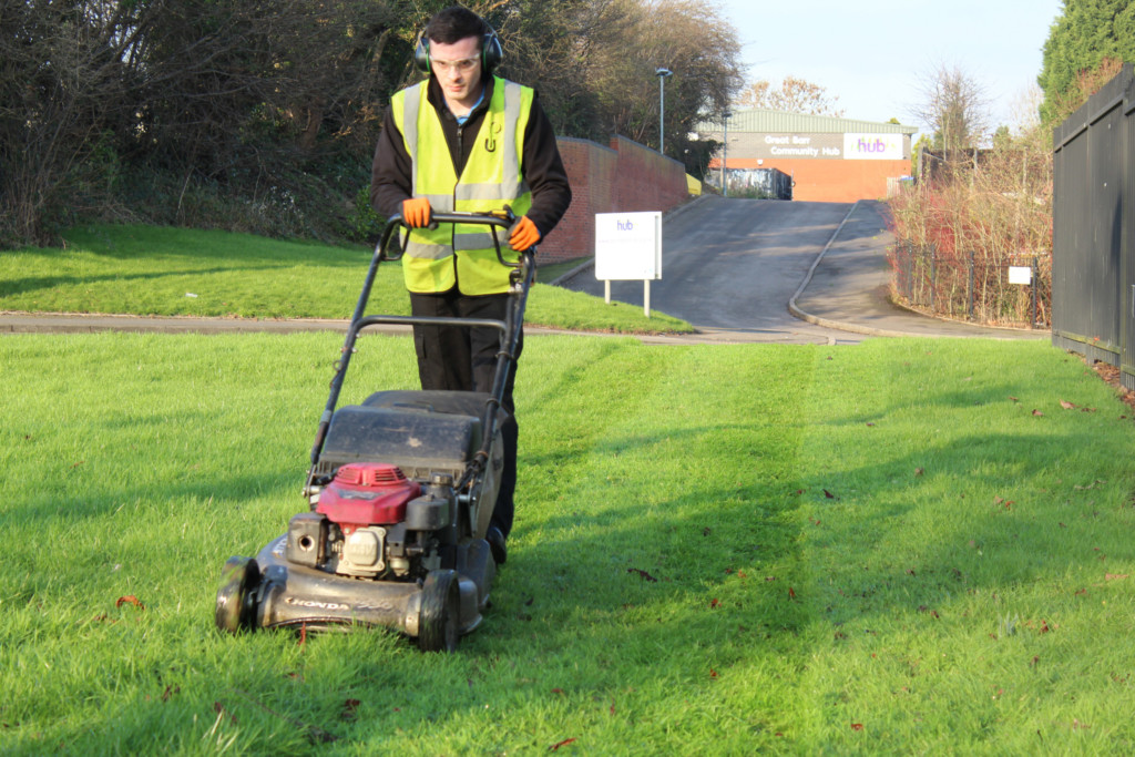Urban Technician is cutting grass
